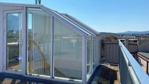 A modern glass-enclosed room with a view of the cityscape. - DREAM 360° City Skyline Rooftop Terrace & Balcony (Wien)