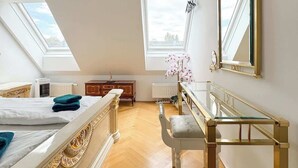 A bedroom with a large bed, a desk, a chair, and a mirror. There are skylights and a view of the sky. - DREAM 360° City Skyline Rooftop Terrace & Balcony (Wien)
