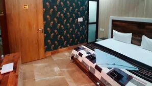 A room with a bed, a wooden door, and a patterned wall. - Hotel Indigo (Rohtak)