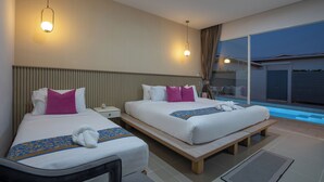 A hotel room with two beds, a small table, a bench, a nightstand, and a view of a swimming pool. - Andaman Sea Best Pool Access & Villas   (Chalong)