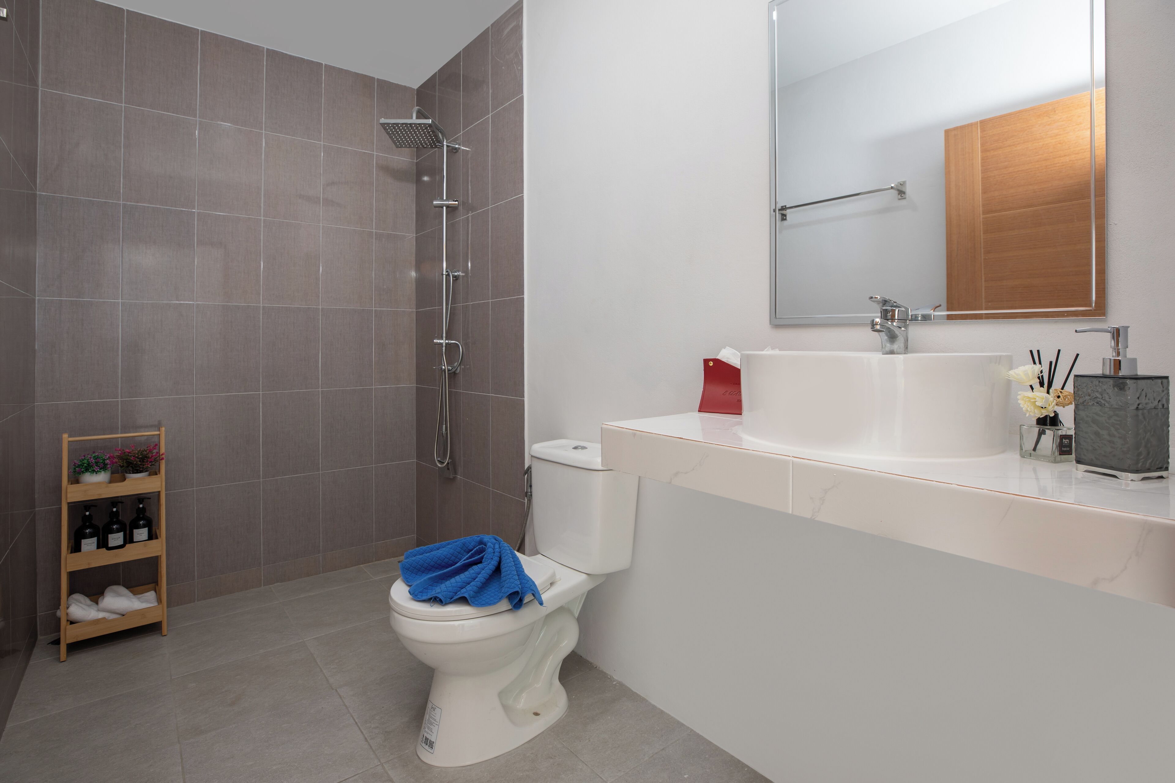 A modern bathroom with a shower, toilet, and sink.