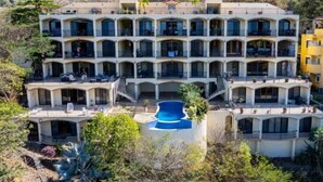 Un hôtel à plusieurs étages doté d’une cour intérieure et d’une piscine.