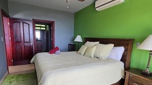 Une chambre à coucher avec un lit, une table de chevet, une lampe et une porte.