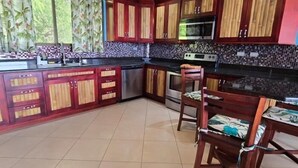 Une cuisine avec des meubles de rangement en bois, un four à micro-ondes et une cuisinière.