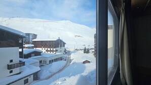 A snow-covered mountain landscape with buildings and a ski lift. - Hôtel Le Ski d'Or (Tignes)