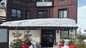 A hotel named "HOTEL LE SKI D'OR" with a snow-covered entrance and potted plants. - Hôtel Le Ski d'Or (Tignes)