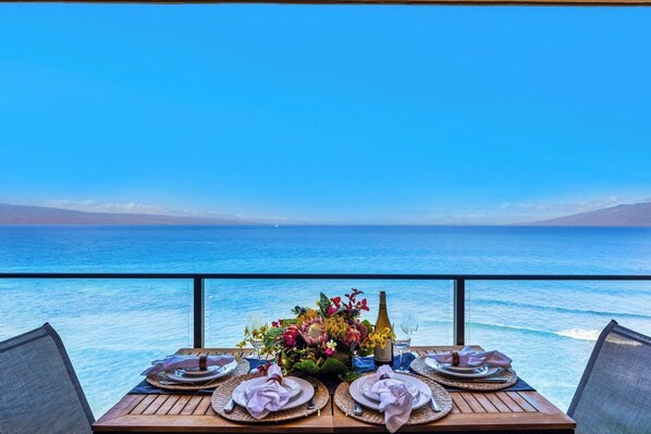A table set for dining with a view of the ocean.