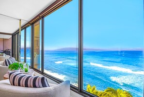 Ein modernes Wohnzimmer mit großen Fenstern und Blick auf den Küsten-Ozean.