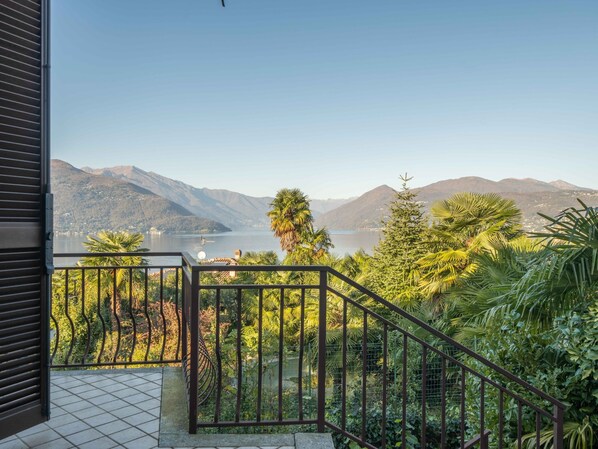 Un balcón con vista a un lago y montañas.