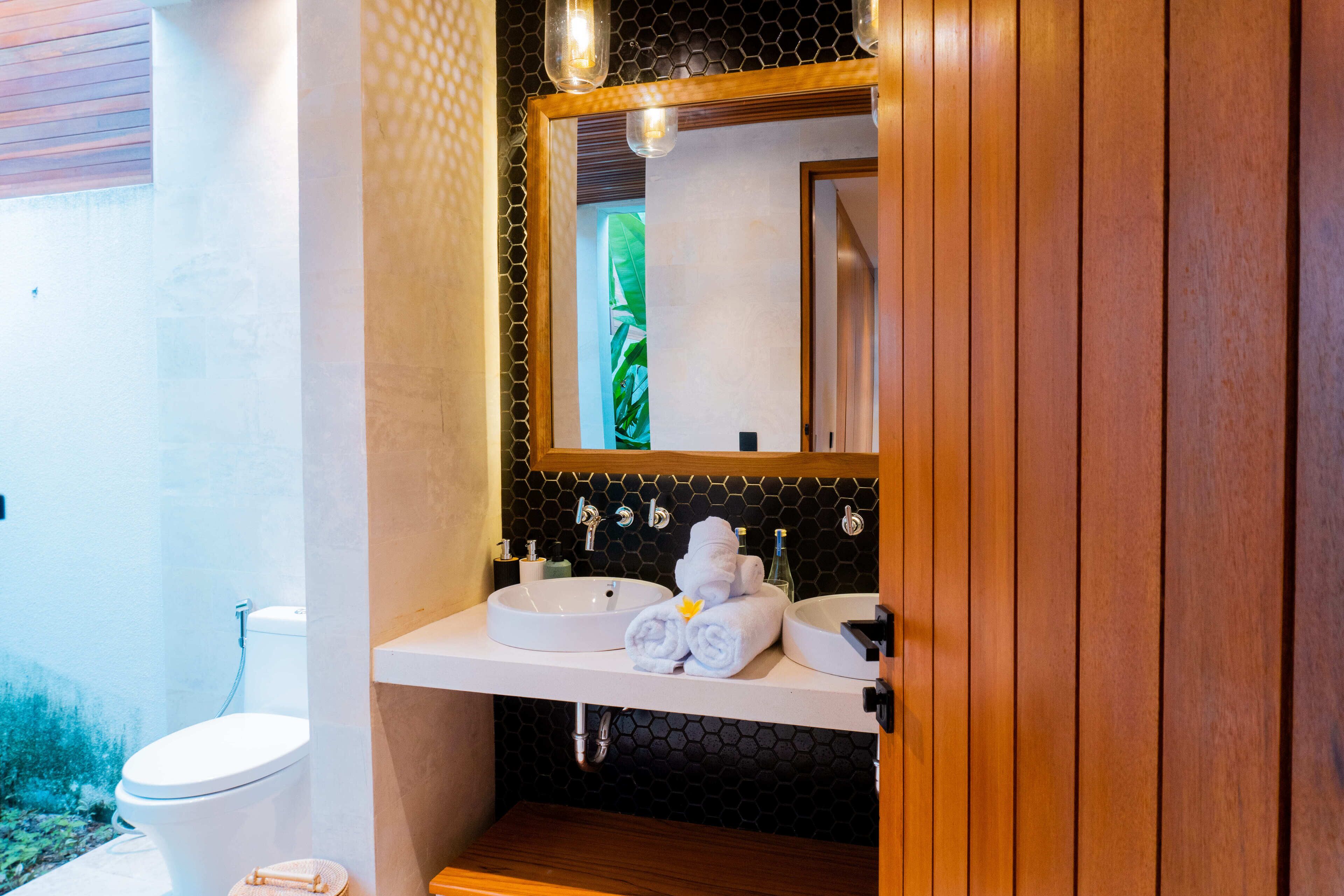 Une salle de bain avec un lavabo blanc, un miroir et un porte-serviettes.