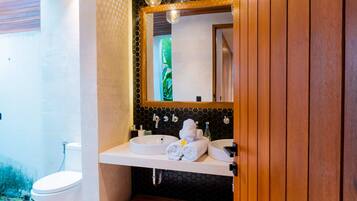 Une salle de bain avec un lavabo blanc, un miroir et un porte-serviettes.