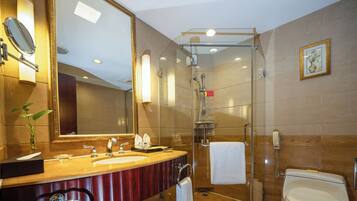 A modern bathroom with a glass-enclosed shower, a large mirror, a vanity with a sink, and a toilet.