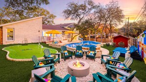A backyard with a fire pit, outdoor seating, a pool, and a small house. - The Sunburst: Sleeps 18! Basketball & Heated Pool (San Antonio)