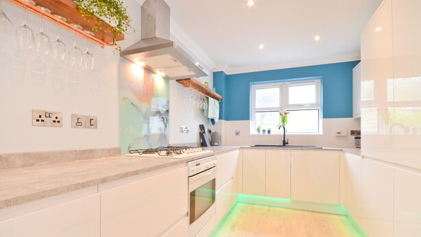 A modern kitchen with white cabinets, a gas stove, and a window with a view. - Princes Esplanade (Gurnard)