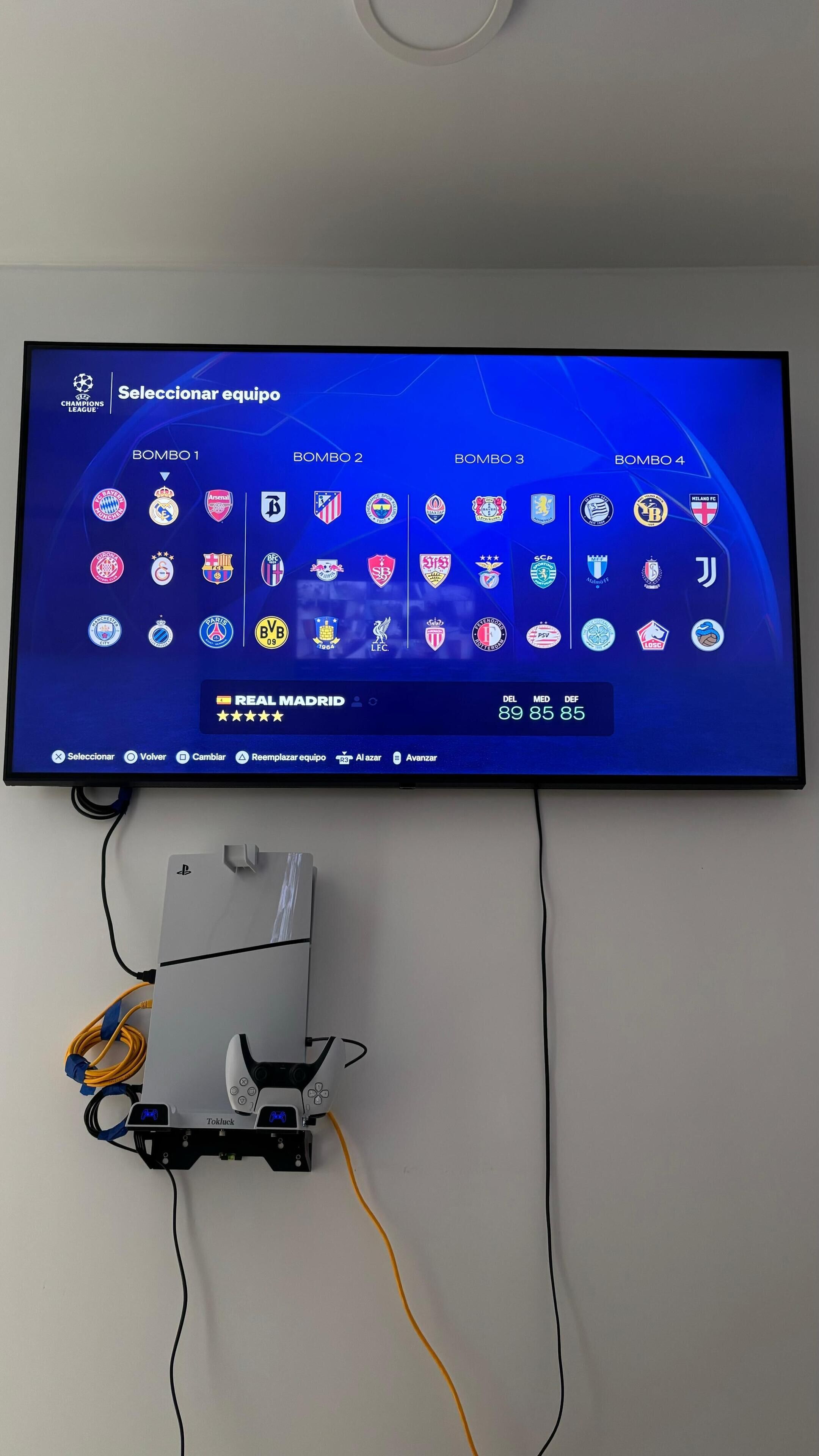 Un televisor instalado en una pared mostrando la selección de un equipo de fútbol.