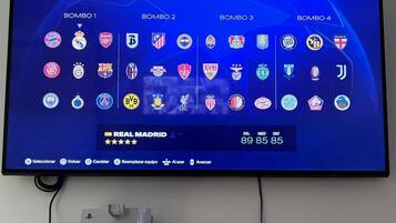 Un televisor instalado en una pared mostrando la selección de un equipo de fútbol.
