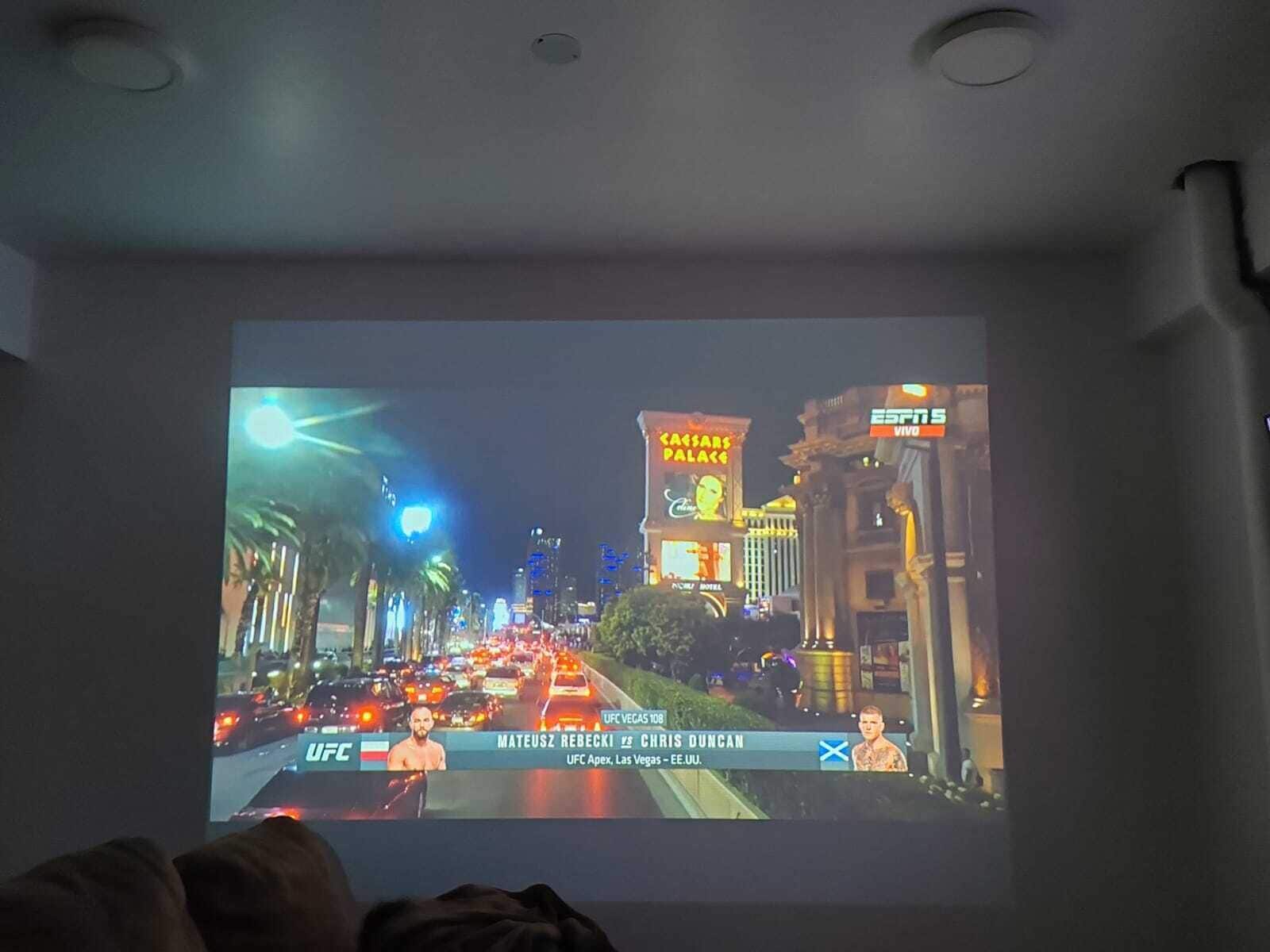 Proyección de una calle de la ciudad con una transmisión de un combate de UFC.