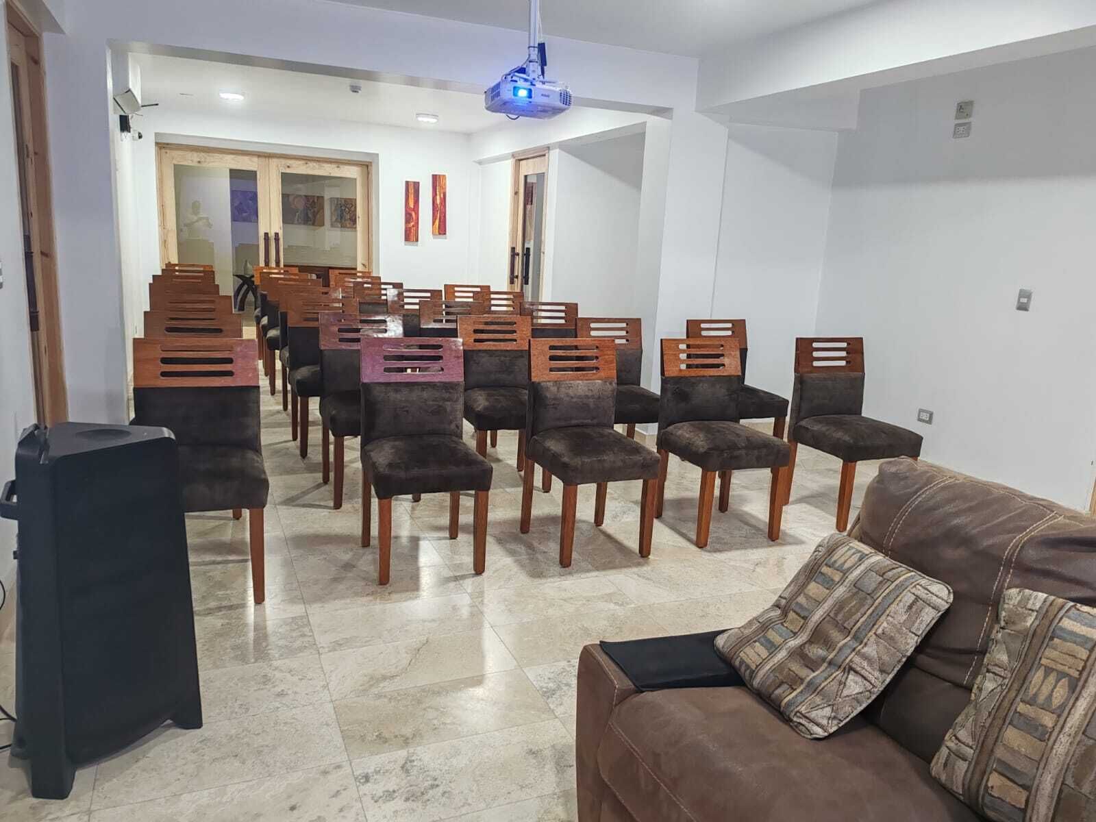 Un coin repas avec des chaises en bois et un canapé marron.