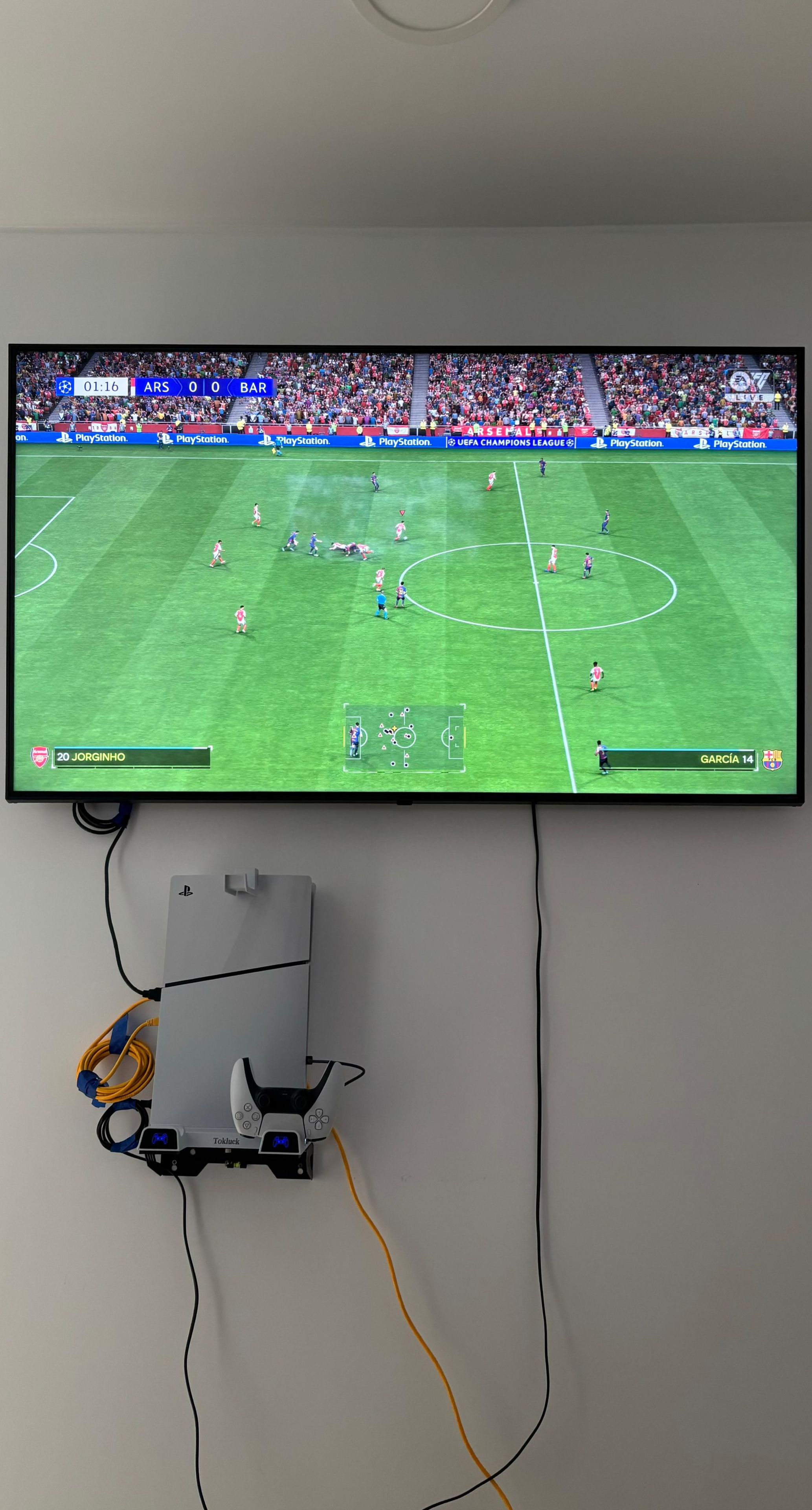 Une console PlayStation connectée à un téléviseur qui affiche un jeu vidéo de football.
