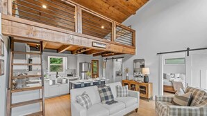 A spacious living area with a loft bedroom, a kitchenette, and a dining area. - Sunsets on Garren Cove (Morganton)