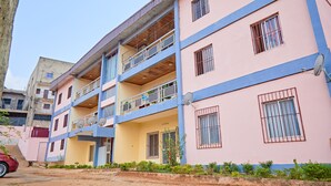 Un edificio residencial de varios pisos con balcones, antenas parabólicas y rejas en las ventanas.