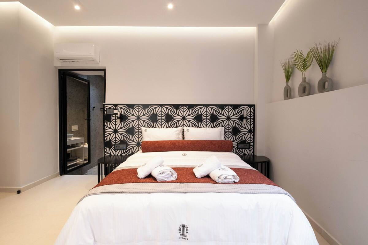 Een moderne hotelkamer met een groot bed, een inbouwkleerkast en een klein nachtkastje.