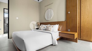 Un dormitorio moderno con una cama grande, cabecera de madera y un adorno de macramé colgante en la pared.