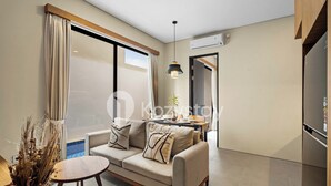 Una sala moderna con un sofá, una pequeña mesa redonda y un jarrón decorativo.