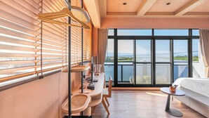 A modern hotel room with a large window, a wooden ceiling, a desk with a chair, and a bed. - Between River and Sea (Wujie)