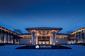 A modern hotel entrance with a covered walkway, large pillars, and a well-lit facade. - Tianfu International Hotel Complex  (Chengdu)