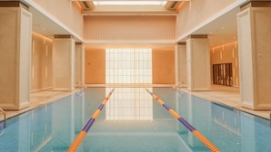 Une piscine avec des couloirs bien délimités, un plafond haut doté de lucarnes et un aménagement intérieur moderne.