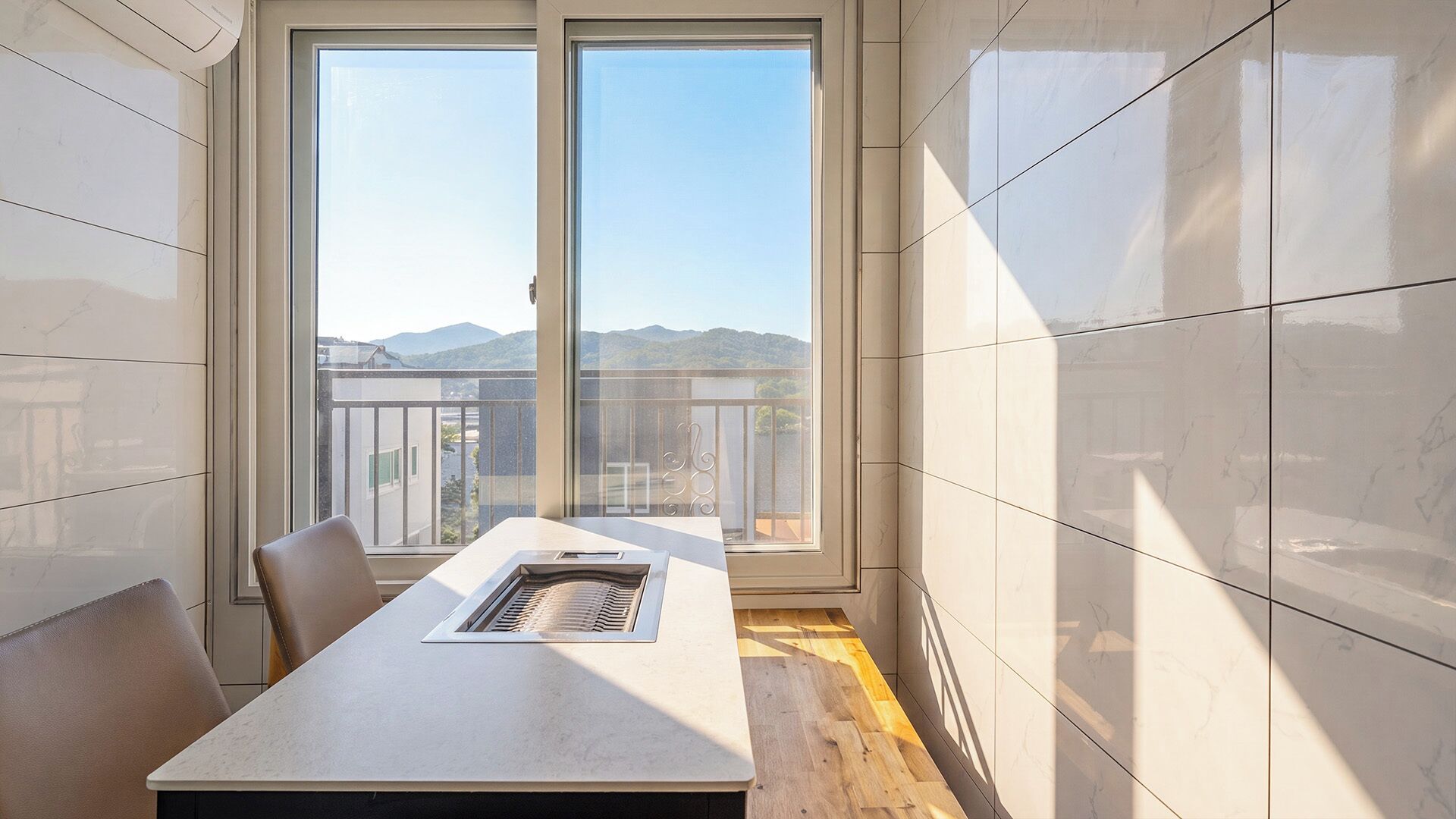A modern room with a large window, a table, and a chair.