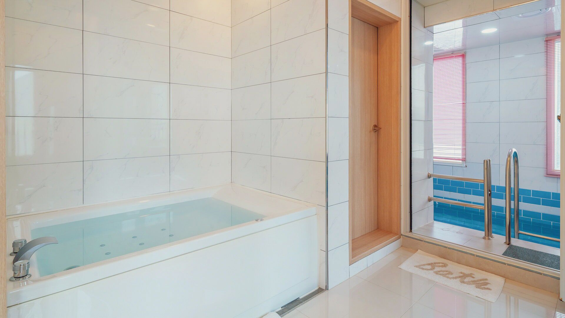 A bathroom with a bathtub, a shower area, and a glass door leading to a pool.