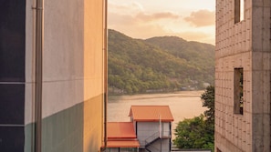 A view of a river with a building in the foreground and a forested hill in the background. - Gapyeong Binchelo Pool Villa Spa Pension (Gapyeong)