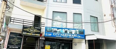 A multi-story building with a sign for 'Hotel Heaven' and a 'City Hardware' store.