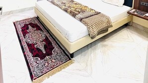 Une chambre d’hôtel moderne avec un grand lit, un ventilateur de plafond et un fauteuil rouge.