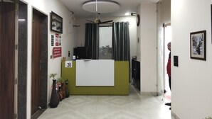 Un espace d’accueil comprenant un comptoir, un ventilateur de plafond et une vue sur l’extérieur par une fenêtre.