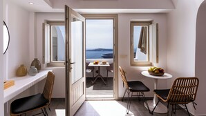 Une chambre moderne avec balcon, une table à manger avec des chaises et une vue sur la mer.