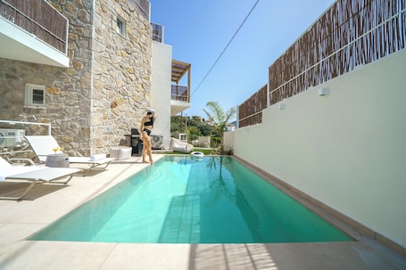 Una piscina al aire libre de temporada, sombrillas