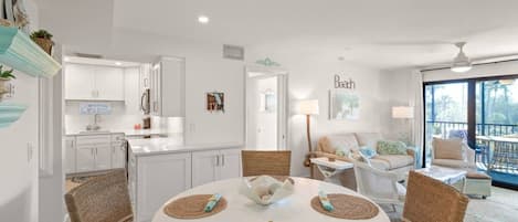 A modern interior with a round dining table, white cabinetry, and a view to the outside.