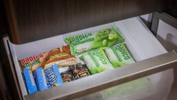 A drawer containing various packaged snacks including chocolate and coffee-flavored items, and green-flavored snacks.