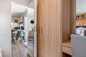 Une cuisine moderne avec un coin repas, des meubles en bois et un petit espace salon.