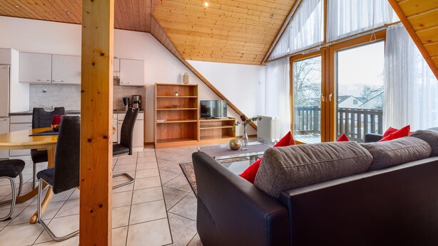 A modern interior with a dining area, kitchen, and living space with a view.