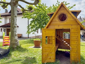 A wooden playhouse with a circular window and a staircase leading to a door. - Apartment 'Konstanz' with Lake View, Shared Garden and Wi-Fi (Hagnau am Bodensee)