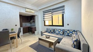 A modern living room with a sofa, coffee table, and dining area. - Bewitchment in Marrakech: A haven of peace in Guéliz, close to Carré Éden (Marrakech)