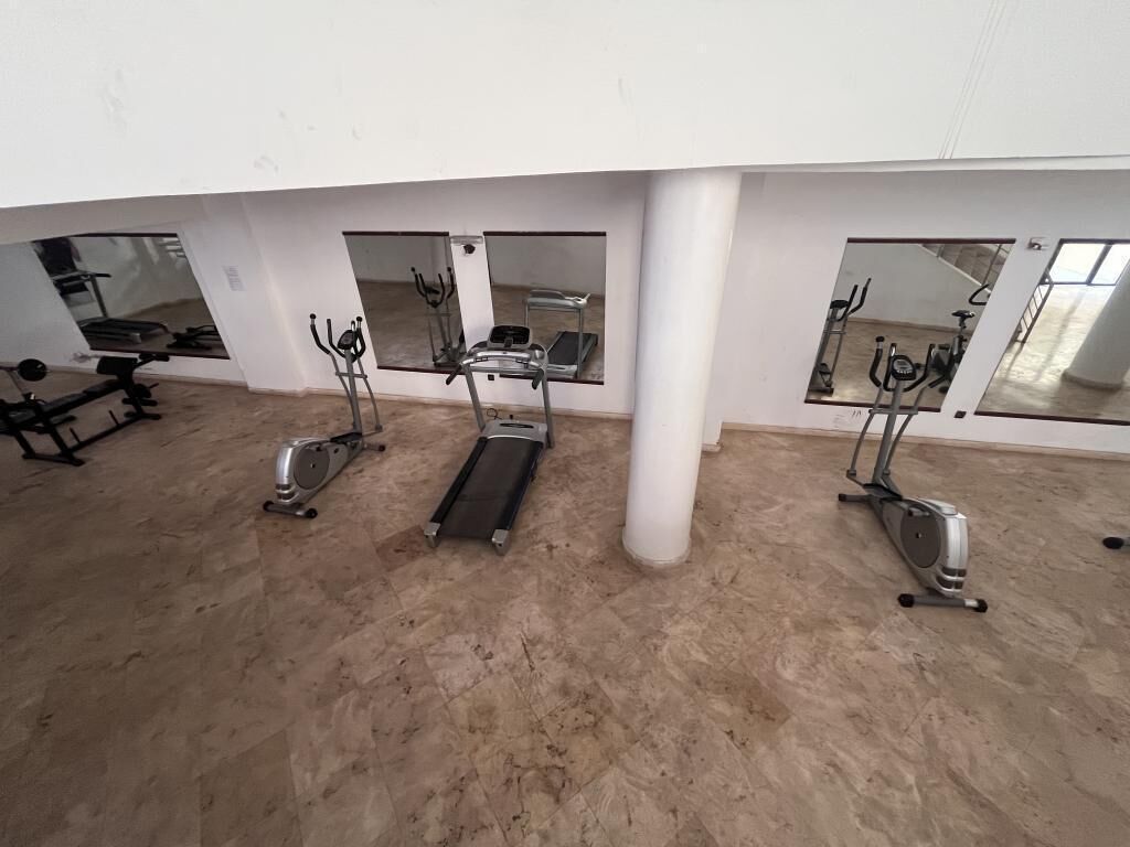 Ein Fitnessstudio mit Laufbändern, Crosstrainern und Ergometer.