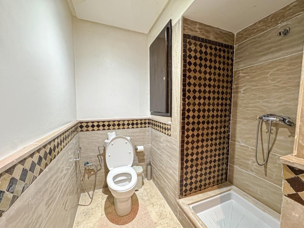 Une salle de bain équipée de toilettes, d’une douche et d’une baignoire.