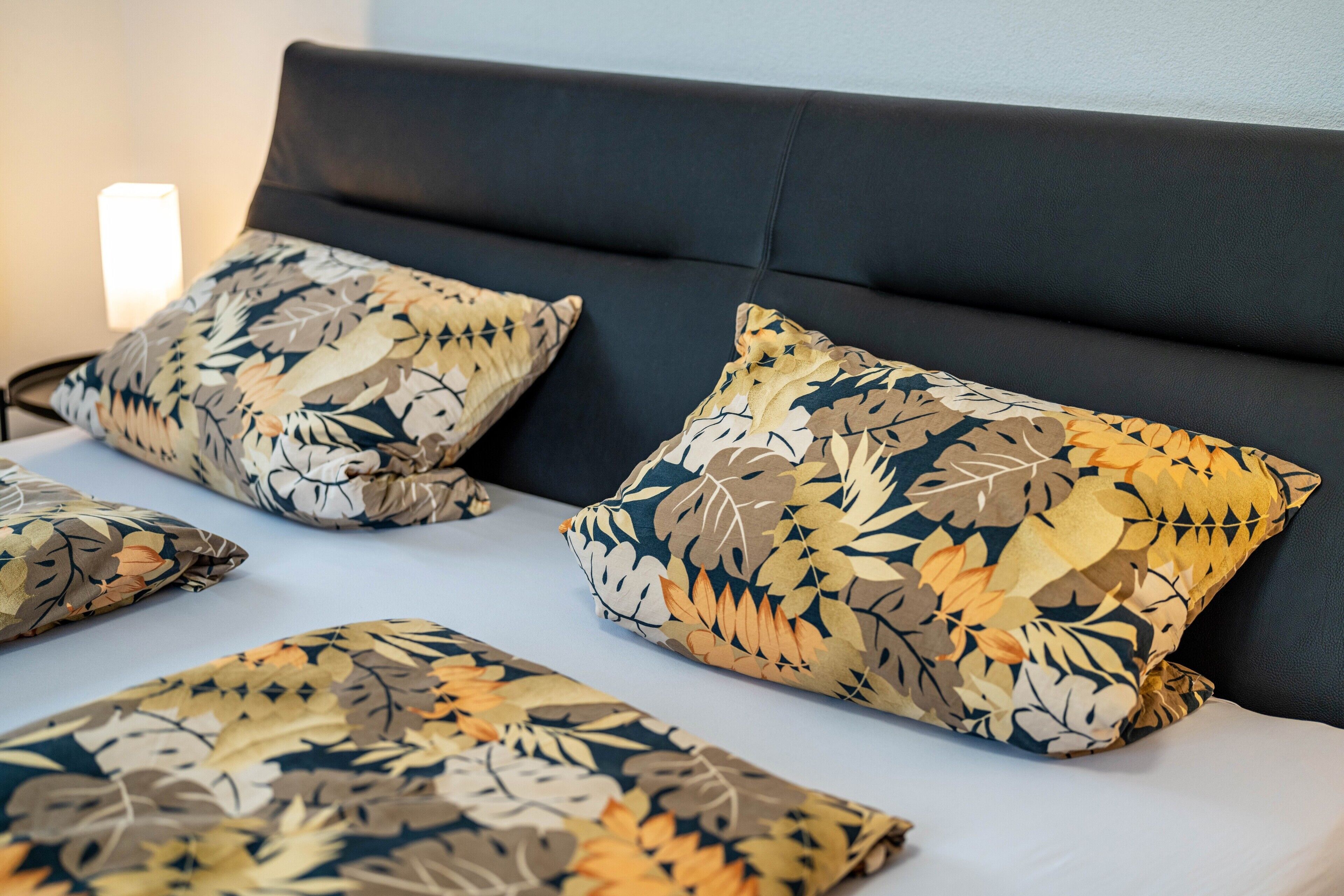 A bed with multiple pillows and a headboard.