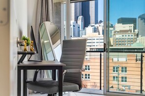 Ein moderner Bürostuhl und Schreibtisch neben einem großen Fenster mit Blick auf die Stadt.
