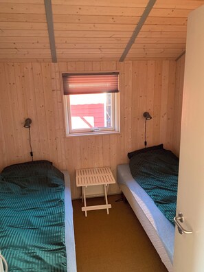 A small room with two beds, a window with a blind, and a small table. - Scenic house on East Funen 200m from the Belt (Frørup)